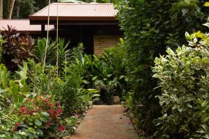 un jardín con muchas plantas y un edificio en Haere Mai I Te Fare en Teavaro