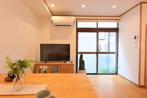a living room with a tv and a large window at OMM STAY in Tokyo