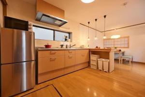 a kitchen with a stainless steel refrigerator and a table at OMM STAY in Tokyo