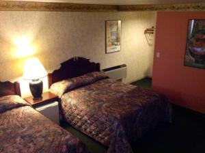 a hotel room with two beds and a lamp at Humboldt Redwoods Inn in Garberville