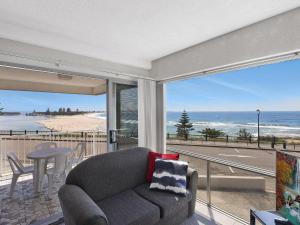 Una sala de estar con un sofá y vista al mar. en Dolphin Court 6, en The Entrance