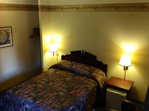 Habitación de hotel con 1 cama y 2 lámparas en Humboldt Redwoods Inn, en Garberville
