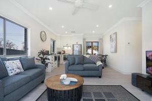 a living room with two couches and a table at Accommodation Hunter - Adams Street Maitland in Maitland