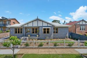 a blue brick house with a fence in front of it at Accommodation Hunter - Adams Street Maitland in Maitland