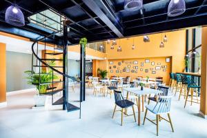 a restaurant with tables and chairs and a staircase at The Rizin in Pattaya South