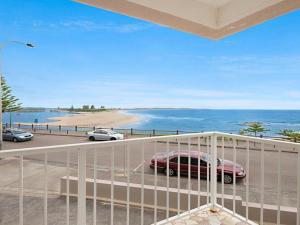 a balcony with a view of a beach and a car at Dolphin Court 6 in The Entrance