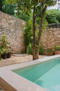 einen Pool vor einer Steinmauer in der Unterkunft Casa Dell´acqua Merida in Mérida