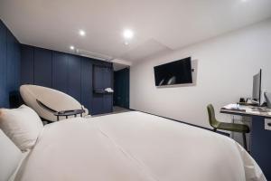 a room with a bed and a desk and a tv at Stay Month Hotel in Goyang