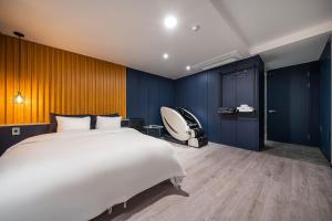 a bedroom with a large bed and a chair at Stay Month Hotel in Goyang