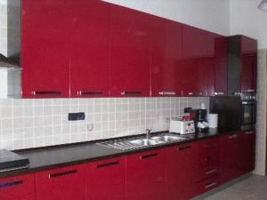 a red kitchen with a sink and red cabinets at B&B Mediterraneo in Torre Melissa