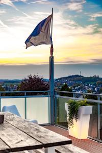 eine Flagge auf einem Balkon mit einem Tisch in der Unterkunft Architektenwohnungen mit Panoramablick bei Köln in Lindlar