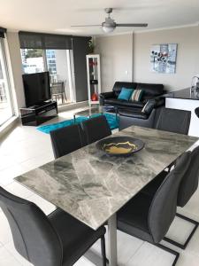 a living room with a table with chairs and a couch at Moorings On Cavill Surfers Paradise in Gold Coast