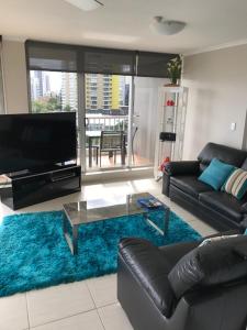 a living room with a couch and a blue rug at Moorings On Cavill Surfers Paradise in Gold Coast