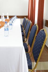 - une longue table avec des bouteilles d'eau assises sur des chaises dans l'établissement Claire de Lune Moonlight Hotel, à Nakuru