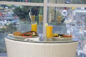 a table with two plates of food and two glasses of orange juice at Claire de Lune Moonlight Hotel in Nakuru