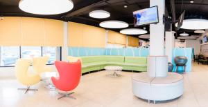 a waiting room with colorful chairs and a tv at Century Hotel in Garapan