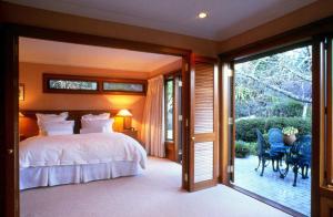 een slaapkamer met een bed en een glazen schuifdeur bij Lake Taupo Lodge in Taupo