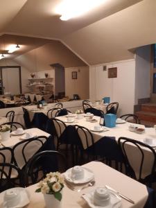a room with tables and chairs with white tablecloths at Hotel Mayorca in Milan +46 photos