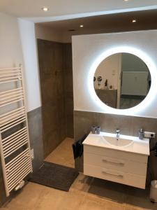 a bathroom with a sink and a mirror at Ermmes Ferienwohnungen in Sinsheim