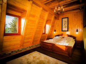 a bedroom with a bed in a wooden cabin at Grabensia Fogadó in Garáb
