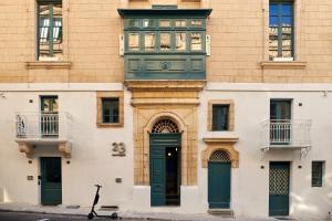 23 Boutique Hotel في إيل فورجانا: مبنى فيه باب أخضر ونافذة