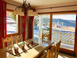 a dining room with a table and a large window at Chalet Le Flocon Bleu - Mauselaine avec vue sur le Lac de Gérardmer in Gérardmer