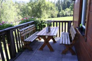 een houten bank op een veranda naast een raam bij Ferienhaus am Mühlbach in Gams bei Hieflau