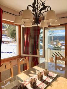 a dining room with a table and a window at Chalet Le Flocon Bleu - Mauselaine avec vue sur le Lac de Gérardmer in Gérardmer