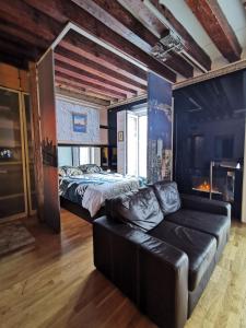 a living room with a bed and a leather couch at Apartamento MADRID CENTRO GRAN VIA - CALLAO in Madrid