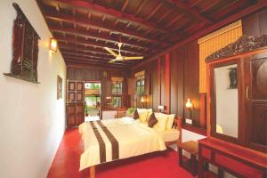 a bedroom with a large bed in a room at Palmdale Heritage in Champakulam