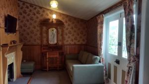 uma sala de estar com um sofá e uma janela em Designer Cottage em Christchurch