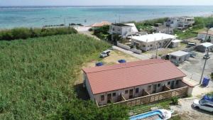 una casa con techo rojo junto al océano en Alezed Villa Shiraho en Isla Ishigaki