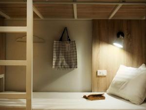 łóżko piętrowe z workiem wiszącym na ścianie w obiekcie A Day inn Ranong Hostel w mieście Ranong