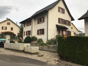 una grande casa bianca con una macchina parcheggiata di fronte di Konditor B & B a Frenkendorf
