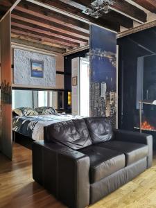 a bedroom with a bed and a leather couch at Apartamento MADRID CENTRO GRAN VIA - CALLAO in Madrid