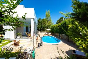 une piscine dans une cour à côté d'une maison dans l'établissement Inn Villa - Pool, BBQ, Playground & Close to Beach, By ThinkVilla, à Pangalochori