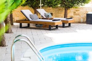 - une piscine avec 2 chaises longues et un parasol dans l'établissement Inn Villa - Pool, BBQ, Playground & Close to Beach, By ThinkVilla, à Pangalochori