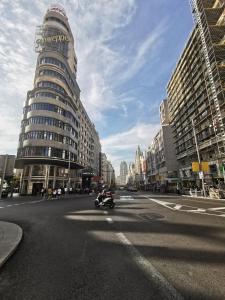 a person riding a motorcycle down a city street at APARTAMENTo MADRID CENTRO GRAN VIA - CALLAO in Madrid