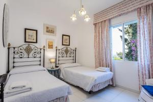 Dos camas en una habitación blanca con ventana. en CASA SAN CAYETANO, en La Herradura 55 fotos más