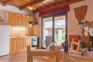 kuchnia z drewnianymi szafkami i dużym oknem w obiekcie Apartment Liznjan 1705 w mieście Ližnjan
