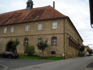 an old brick building with a car parked in front of it at Ferienwohnung Tröppner in Zeilitzheim