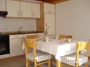 a kitchen with a white table with chairs and a sink at Ferienwohnung Tröppner in Zeilitzheim