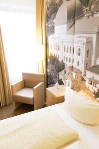um quarto de hotel com uma cama e uma cadeira e uma janela em Hermes Hotel Oldenburg em Oldemburgo