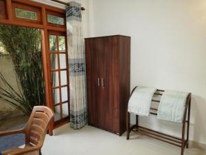 a room with a cabinet and a chair and a window at Mirissa Cocoon in Mirissa
