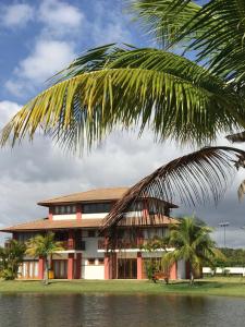 普拉亞多海灘的住宿－village na praia do forte，前面有棕榈树的建筑