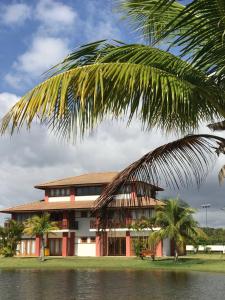 un edificio con una palma di fronte di village na praia do forte a Praia do Forte