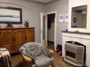ein Wohnzimmer mit einem Stuhl und einem Kamin in der Unterkunft residentie leopold ( 31 ) in Blankenberge