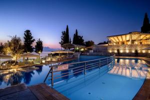 a swimming pool in front of a building at night at Porto Galini Seaside Resort & Spa in Nikiana