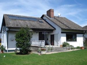 Casa blanca con paneles solares en el techo en Ferienwohnung Tröppner, en Zeilitzheim
