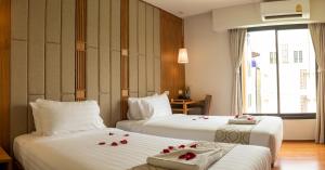 a hotel room with two beds with roses on them at Lanna Thaphae Hotel in Chiang Mai